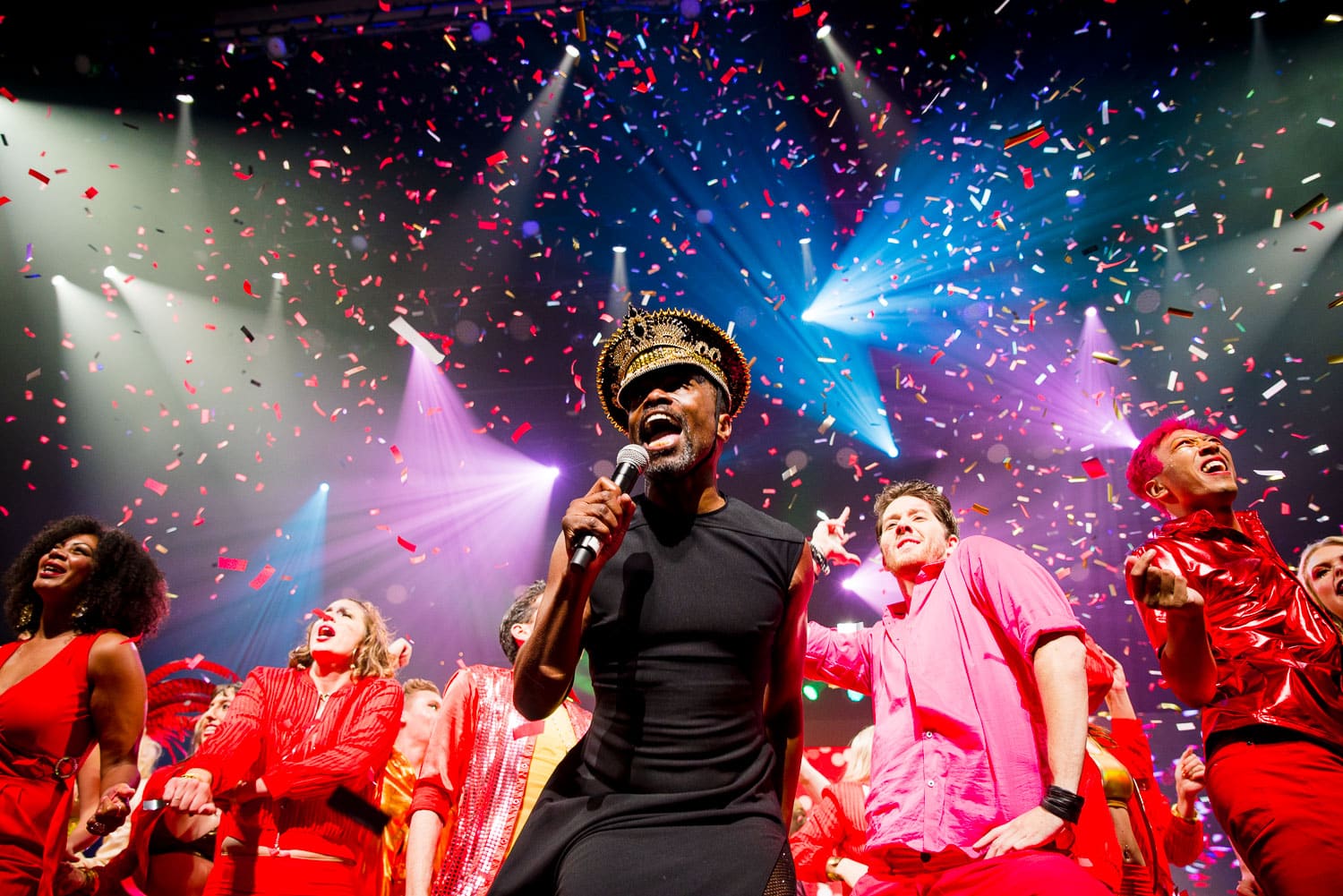 performer singing on colorfully-lit stage