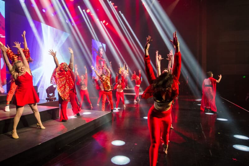 Stage performers under colorful light