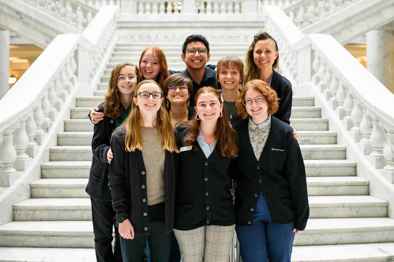 A group of young individuals pose together inside of the capitol building.